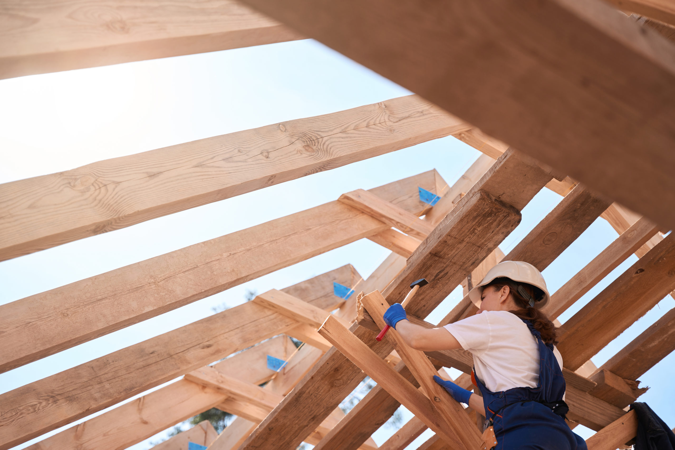 Woman building engineer anchoring roof structure more securely